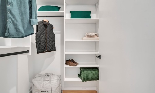 All the comforts of luxury living Walk-in closet with white shelving